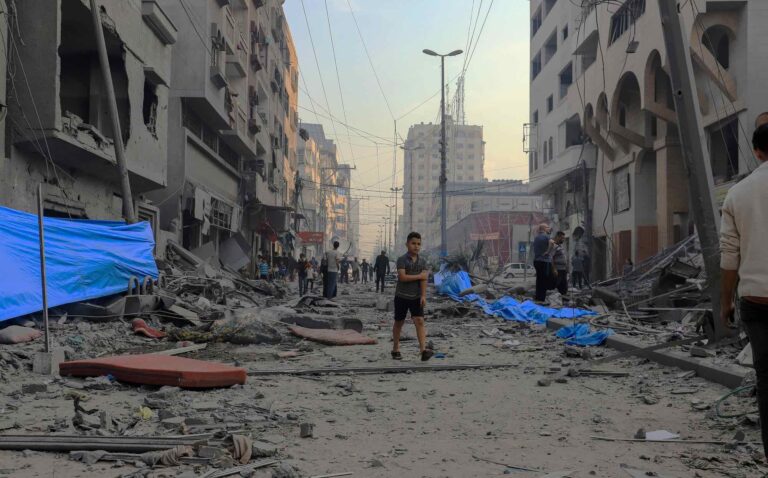 Palestinians inspect the ruins of the Watan Tower, which was destroyed by Israeli air strikes in Gaza City