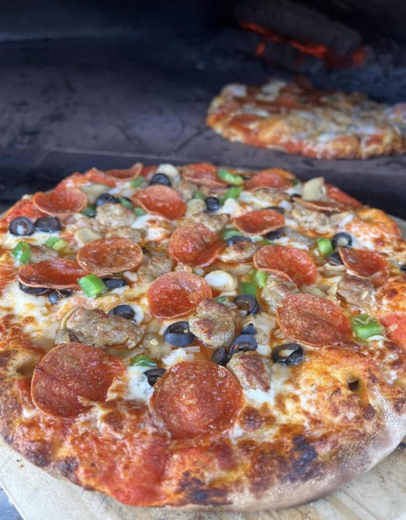 Pizzas coming out of oven at Brick & Ember Pizza Company